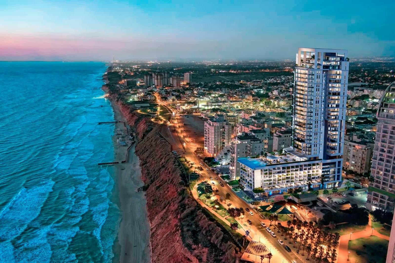 The Blue Cliff, new construction on Nitza Blvd, Netanya: beachfront tower at dusk (developer rendering)